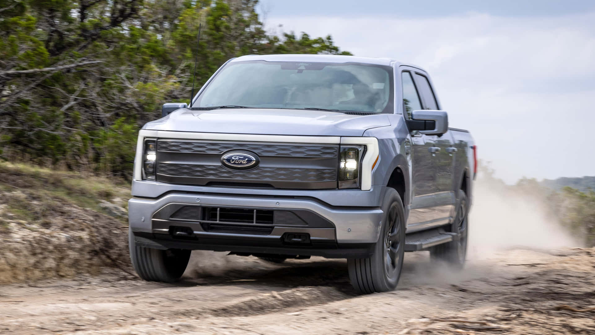 The 2019 Ford F - 150 Is Driving Down A Dirt Road