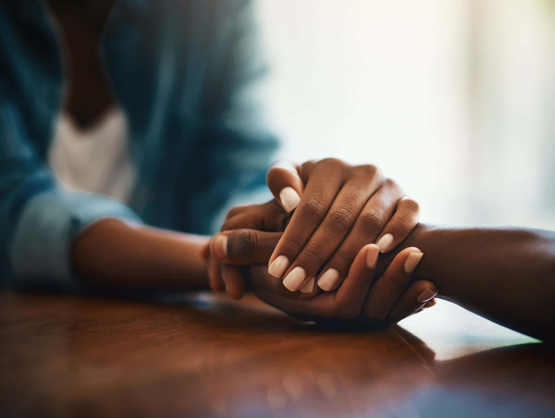 Two People Holding Hands On A Table