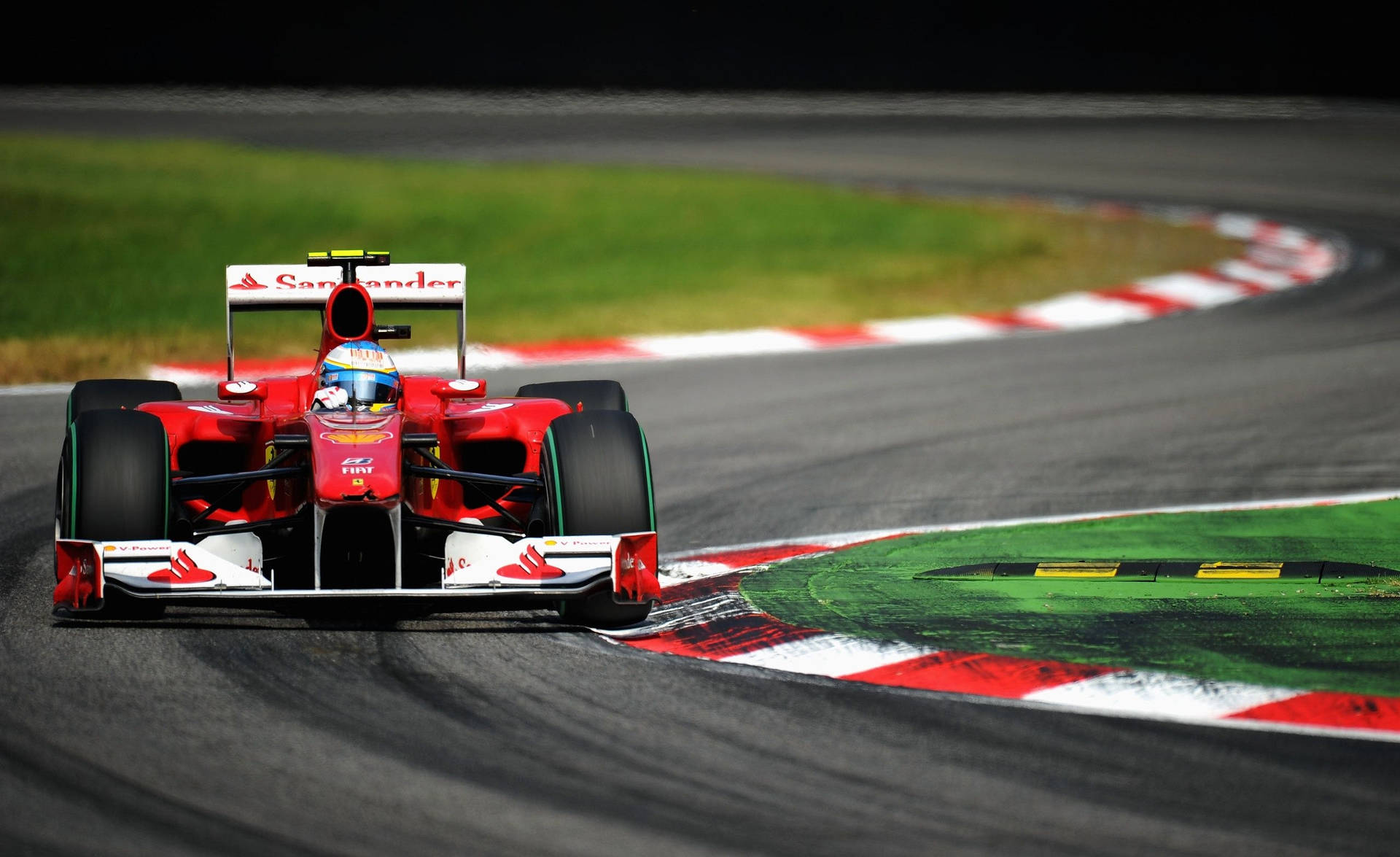 En Ferrari F1-bil kører ned ad en bane Wallpaper