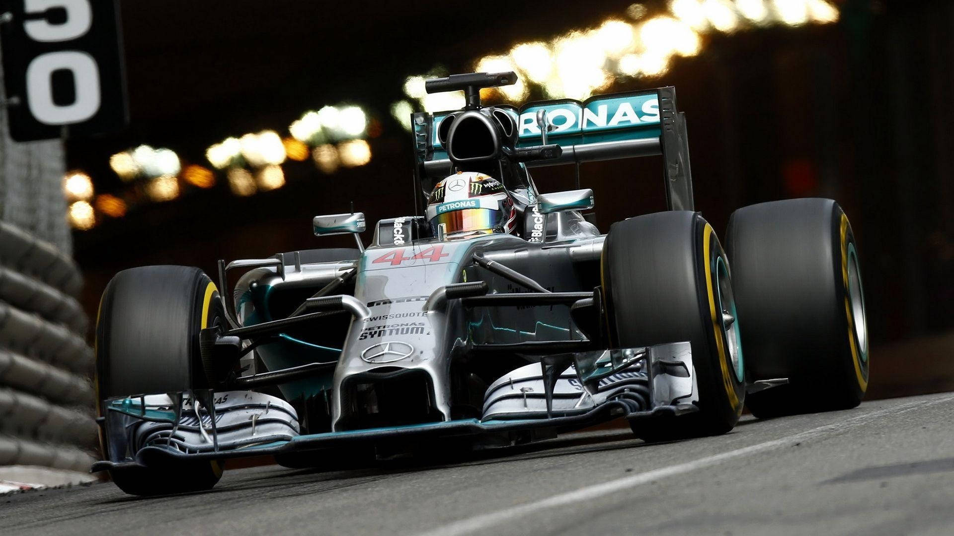 En Mercedes F1 kører ned ad en bane Wallpaper