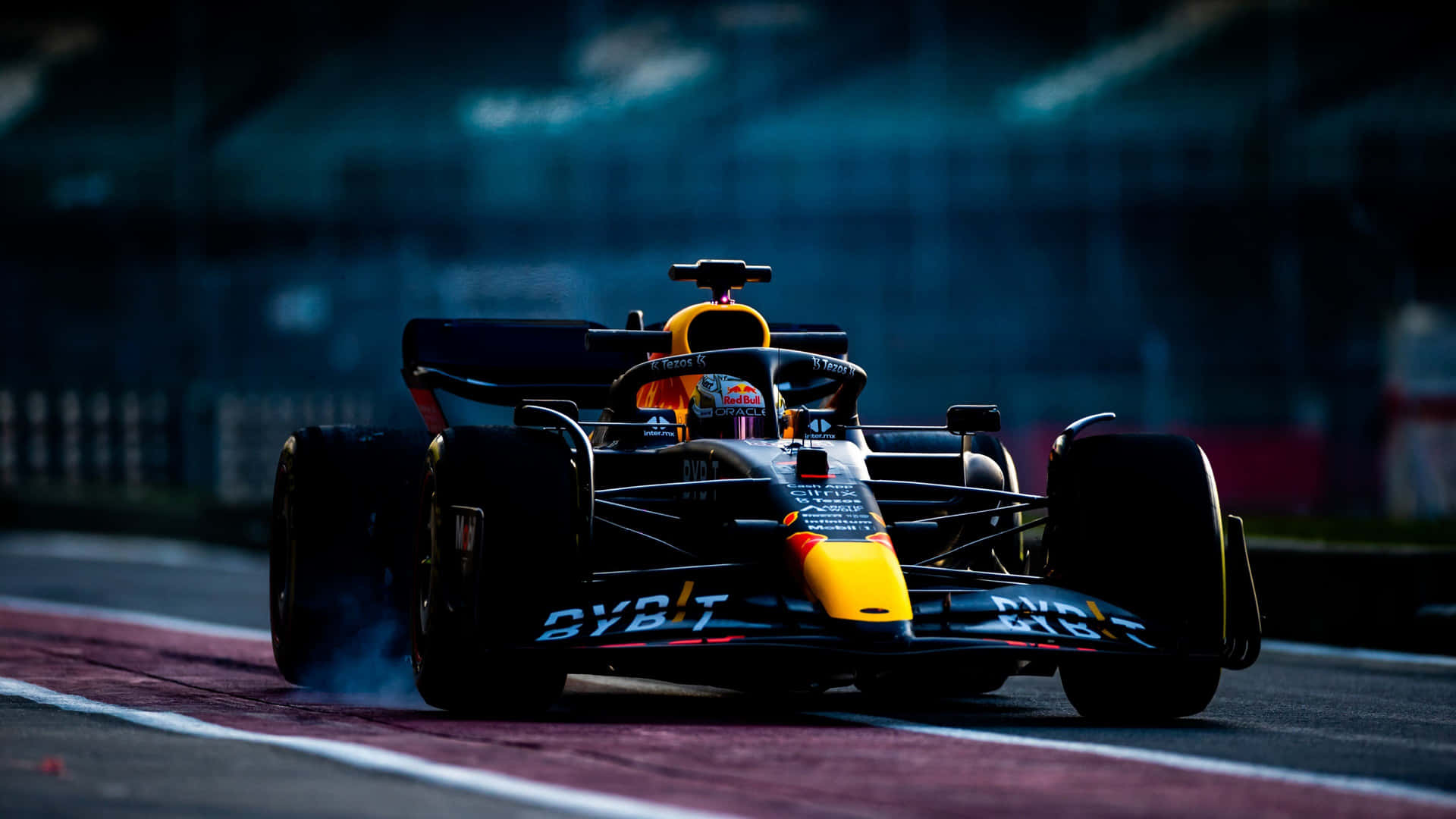 A Red Bull Racing Car Is Driving On A Track Wallpaper