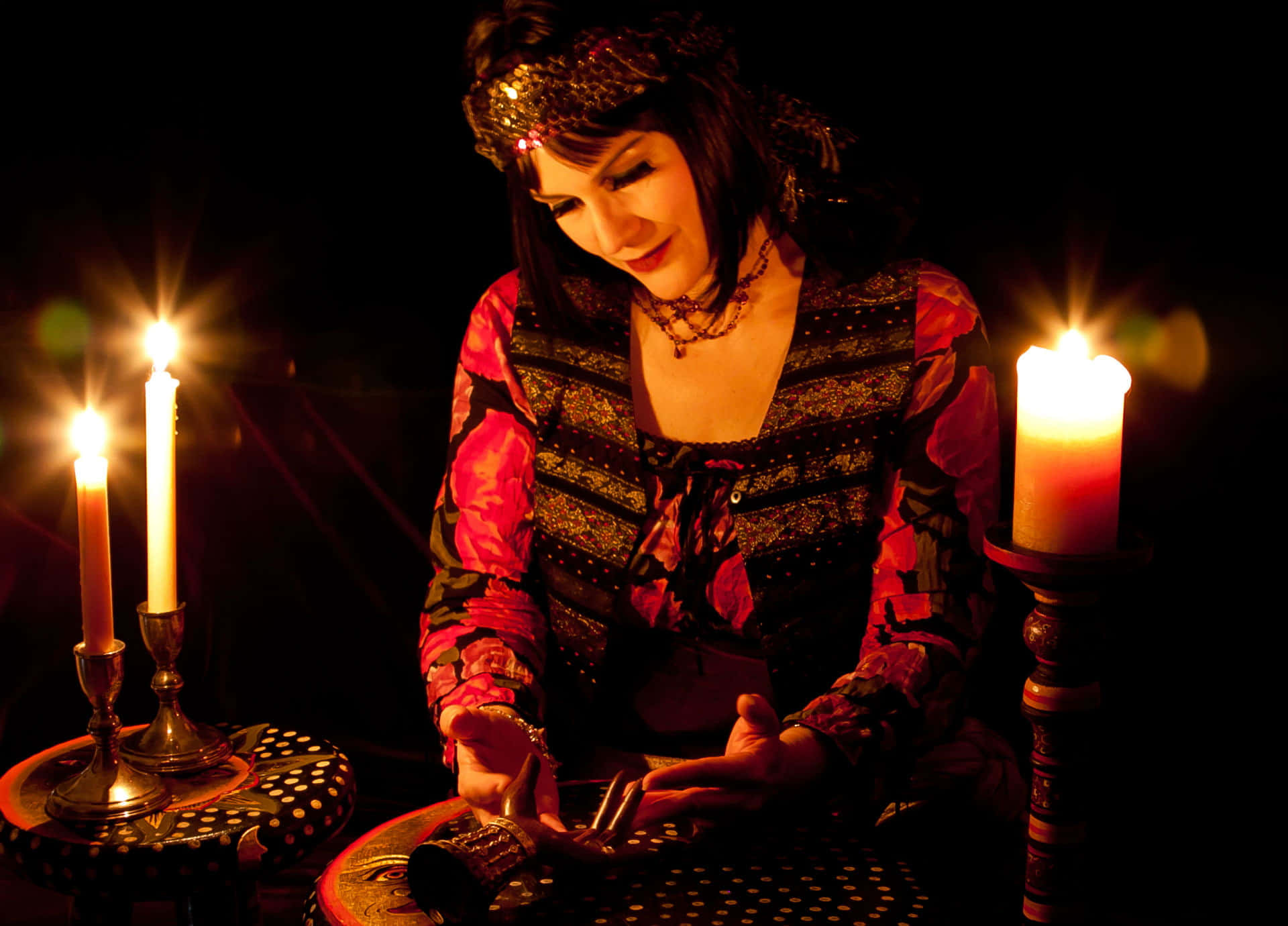 A mystical Fortune Teller with a crystal ball in a dimly lit tent Wallpaper