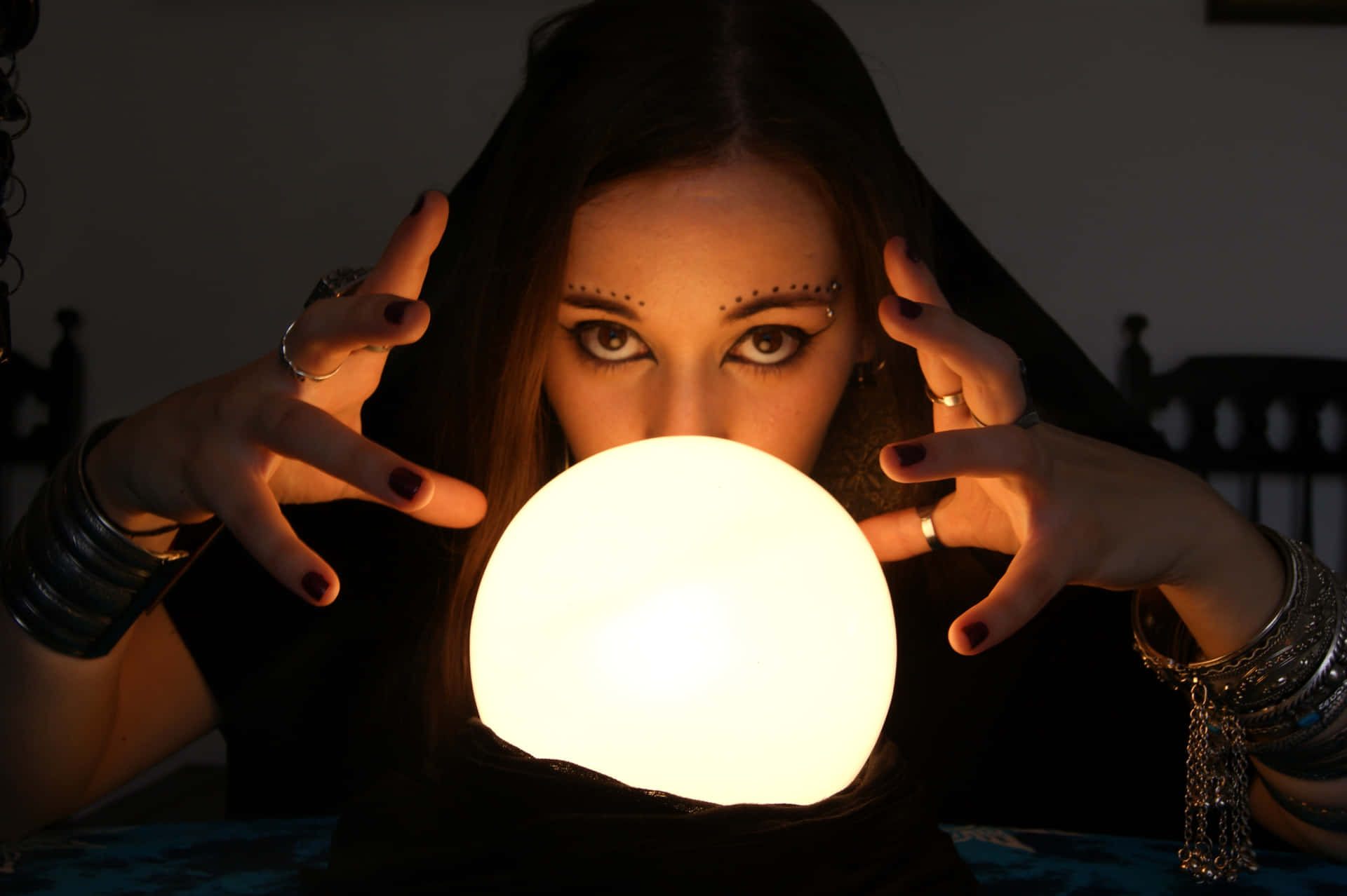 Mysterious Fortune Teller Gazing Into Crystal Ball Wallpaper
