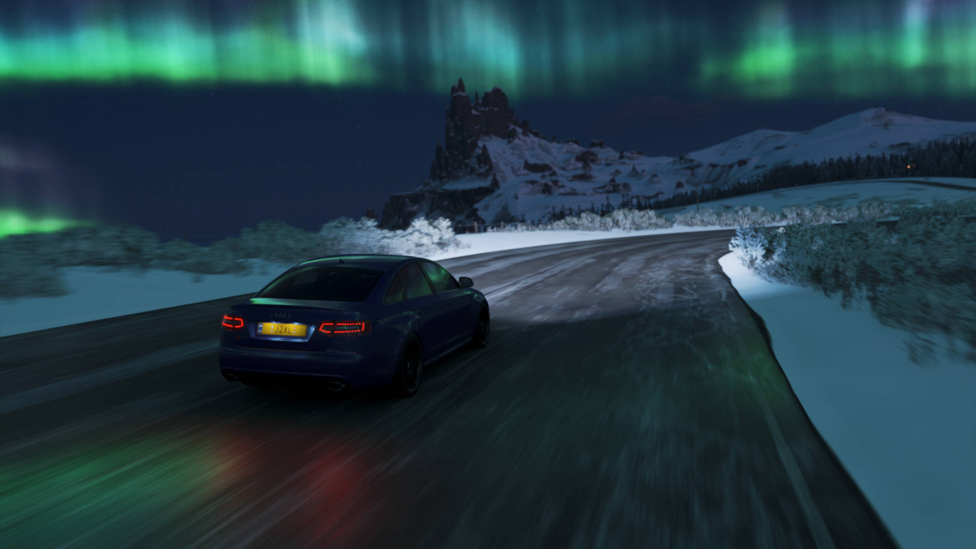 A Car Driving On A Snowy Road With The Aurora Lights On Wallpaper