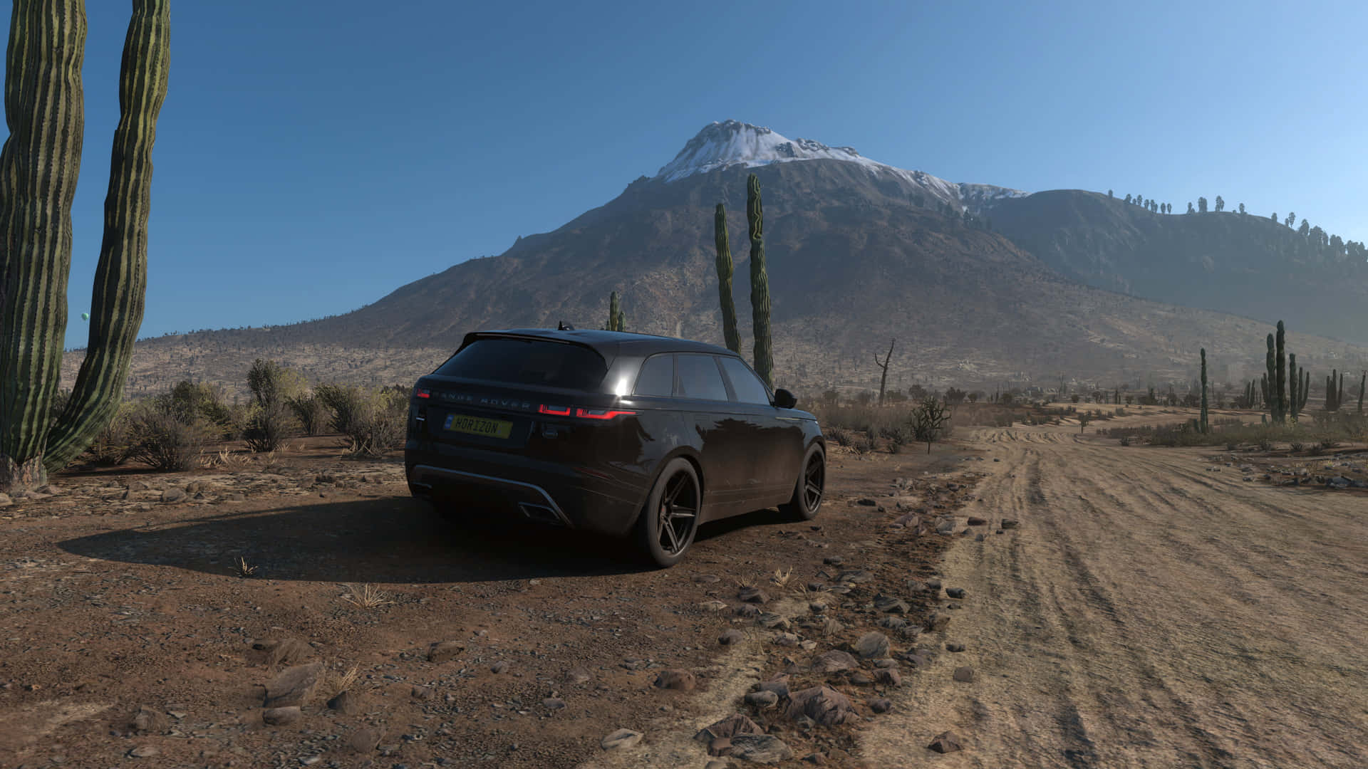 A Black Suv Is Parked On A Dirt Road Near A Mountain Wallpaper