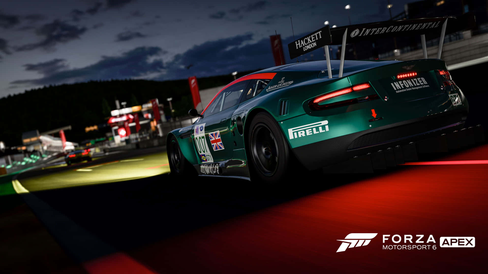 A Green Racing Car Is Driving Down The Track At Night Wallpaper