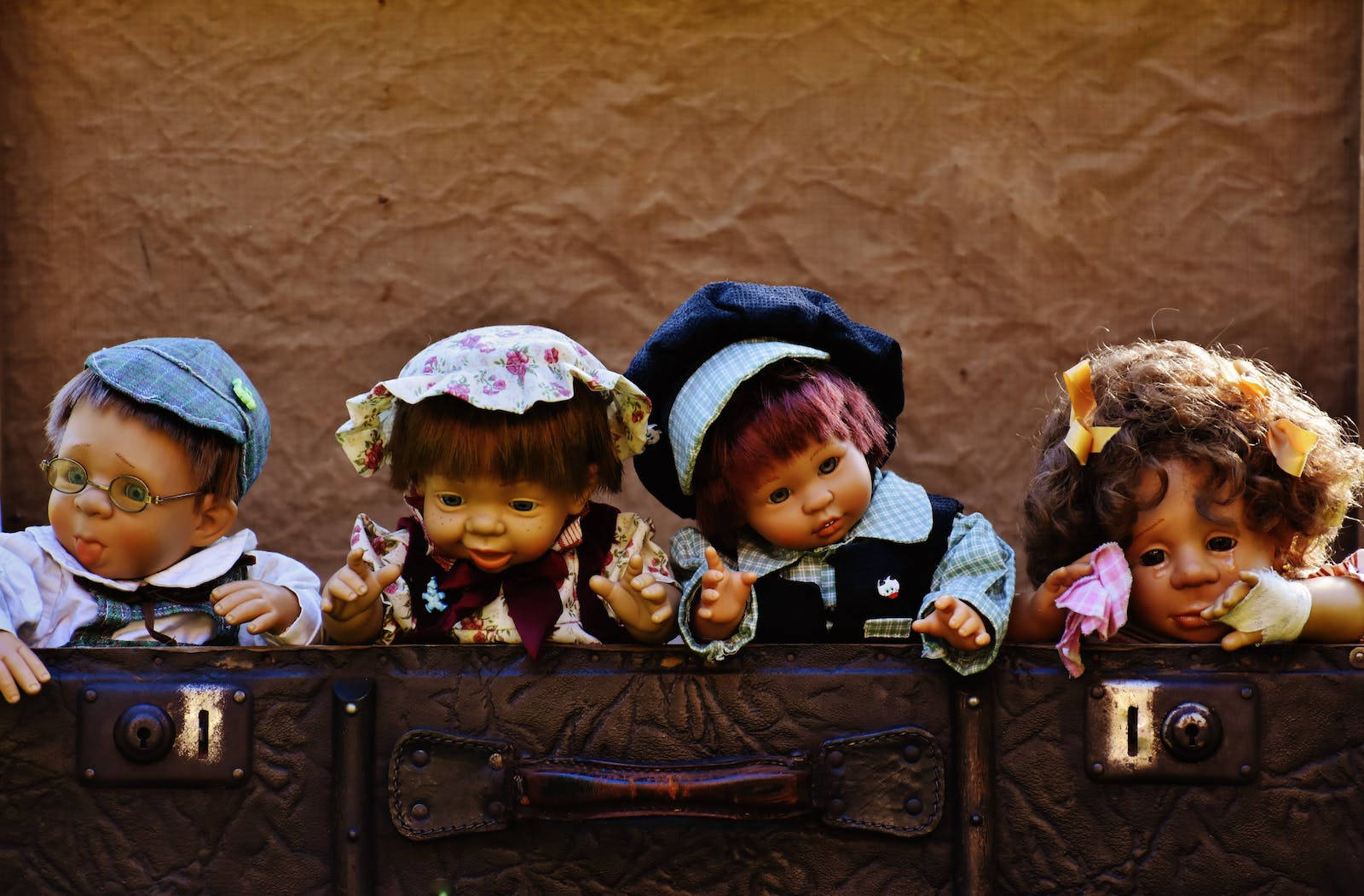 Four Cute Dolls Inside Suitcase Wallpaper