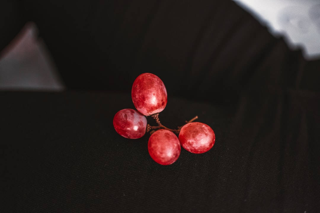 Firer røde druer glider yndefuldt ned på din skærm. Wallpaper