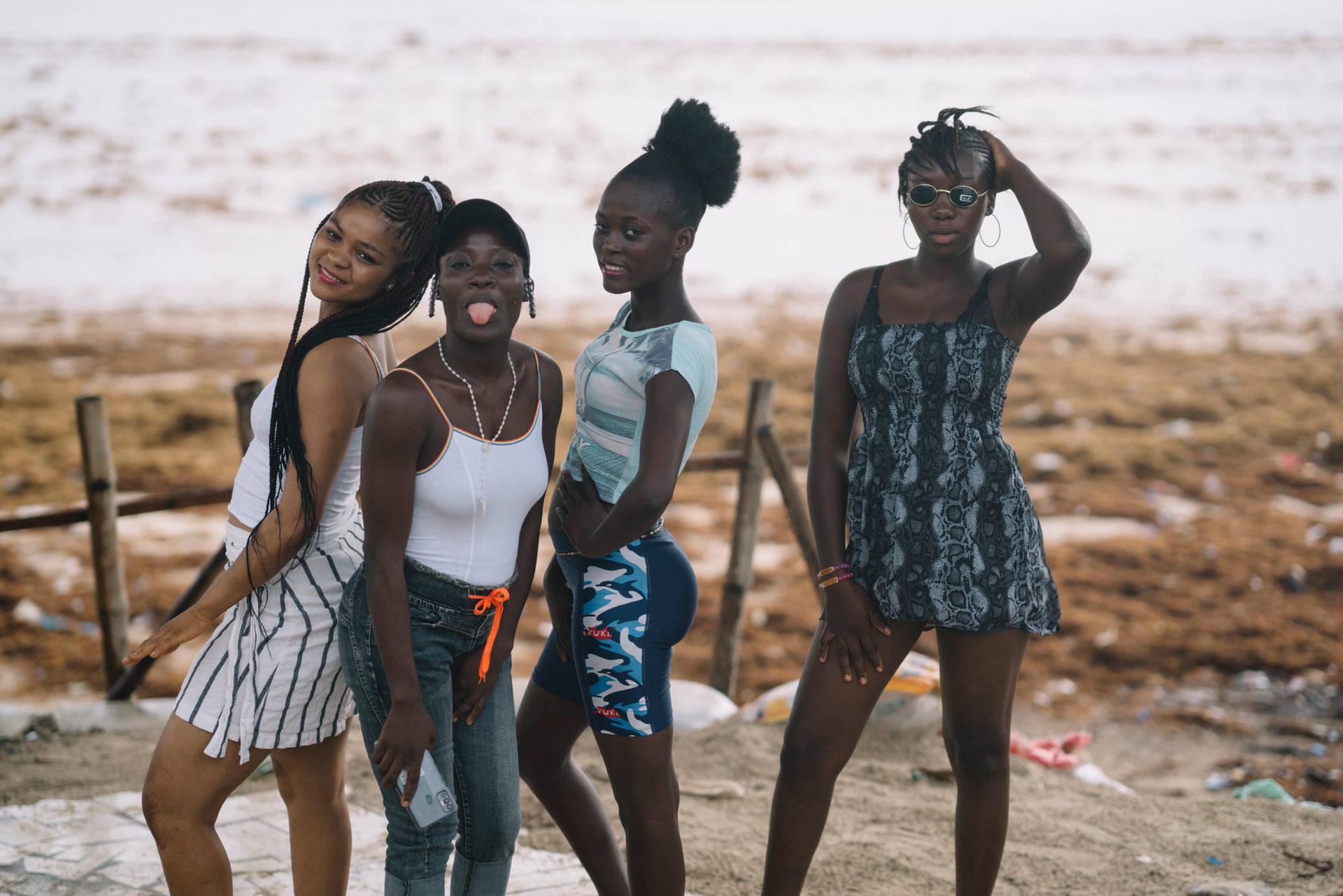 Four Women Posing At Beach In Sierra Leone Wallpaper