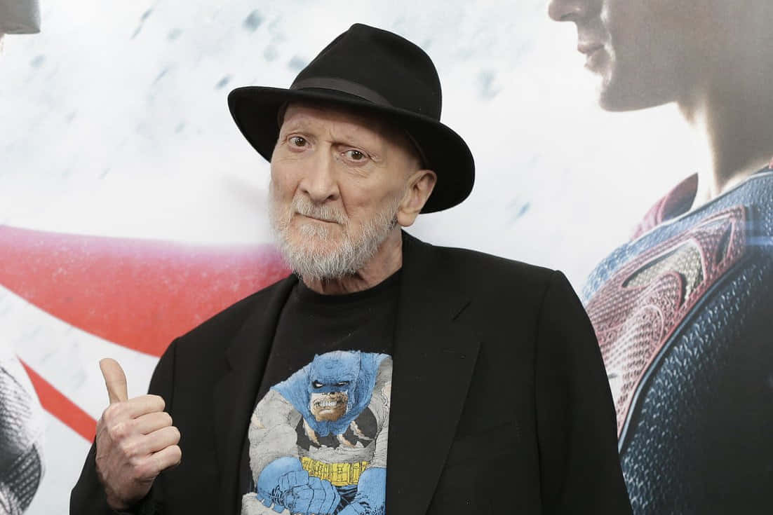 The iconic Frank Miller holding his graphic novel Wallpaper