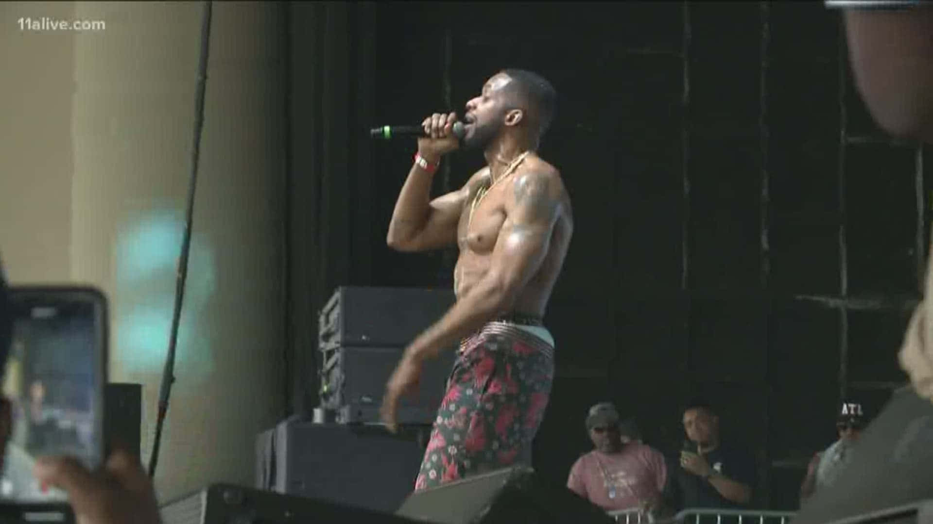 A Man With A Shirt On Is Singing Into A Microphone