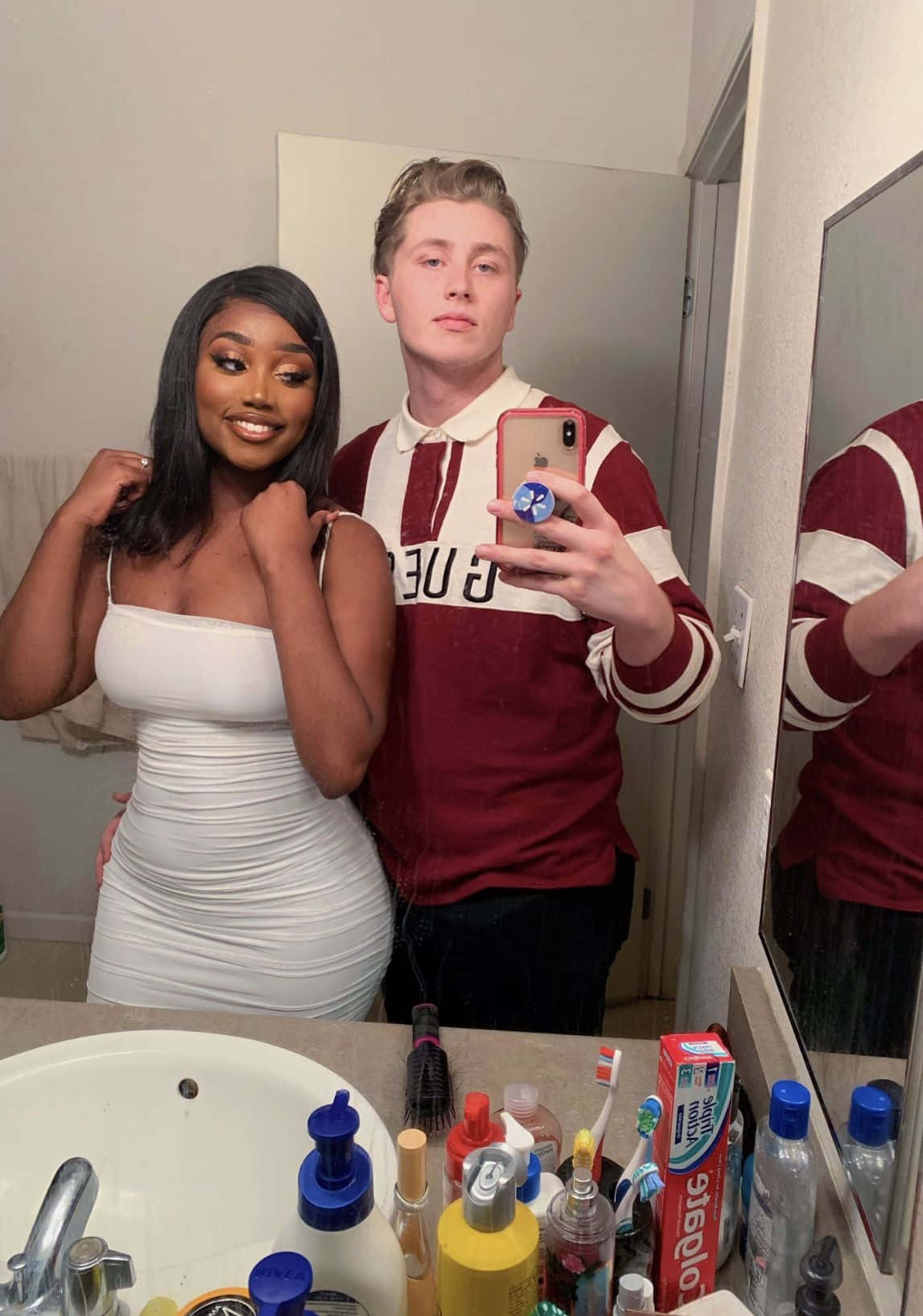 A Man And Woman Taking A Selfie In A Bathroom
