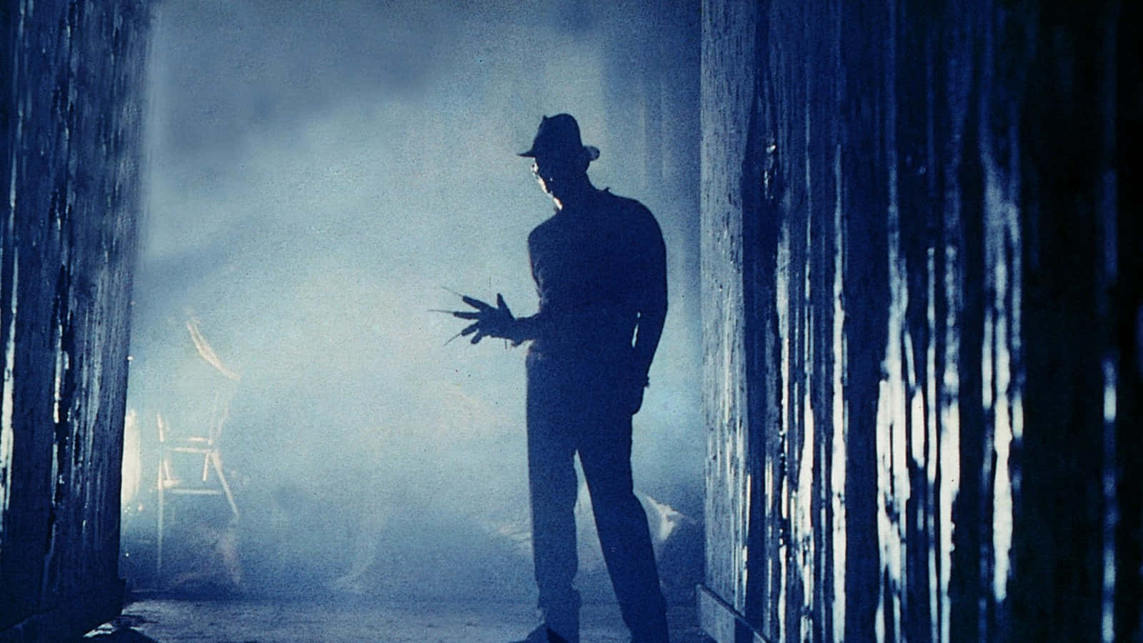 Freddykrueger Fissa Minacciosamente Con Il Suo Guanto E Cappello Famigerati In Un'atmosfera Cupa.