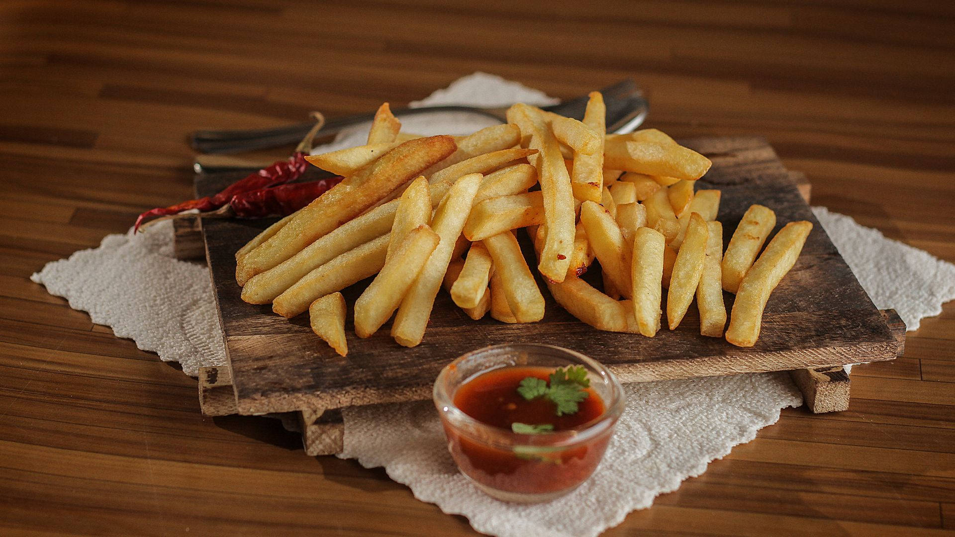 Delicious Golden French Fries on a Rustic Wooden Platter Wallpaper