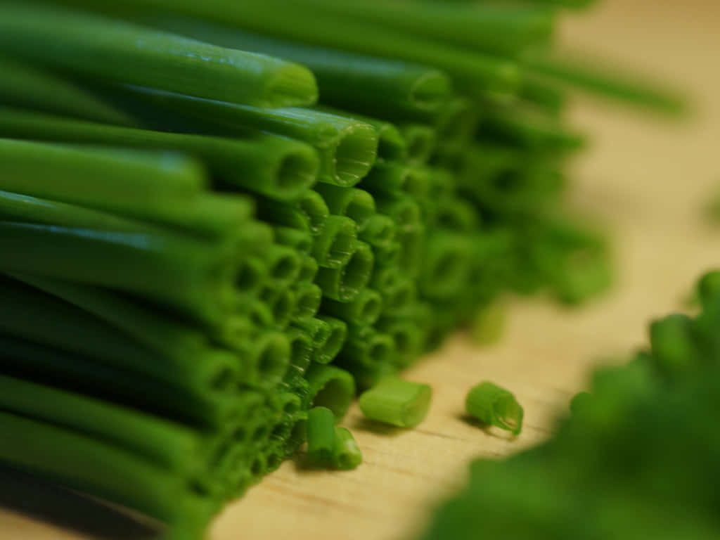 Fresh Chives Chopped On Wooden Chopping Board Wallpaper