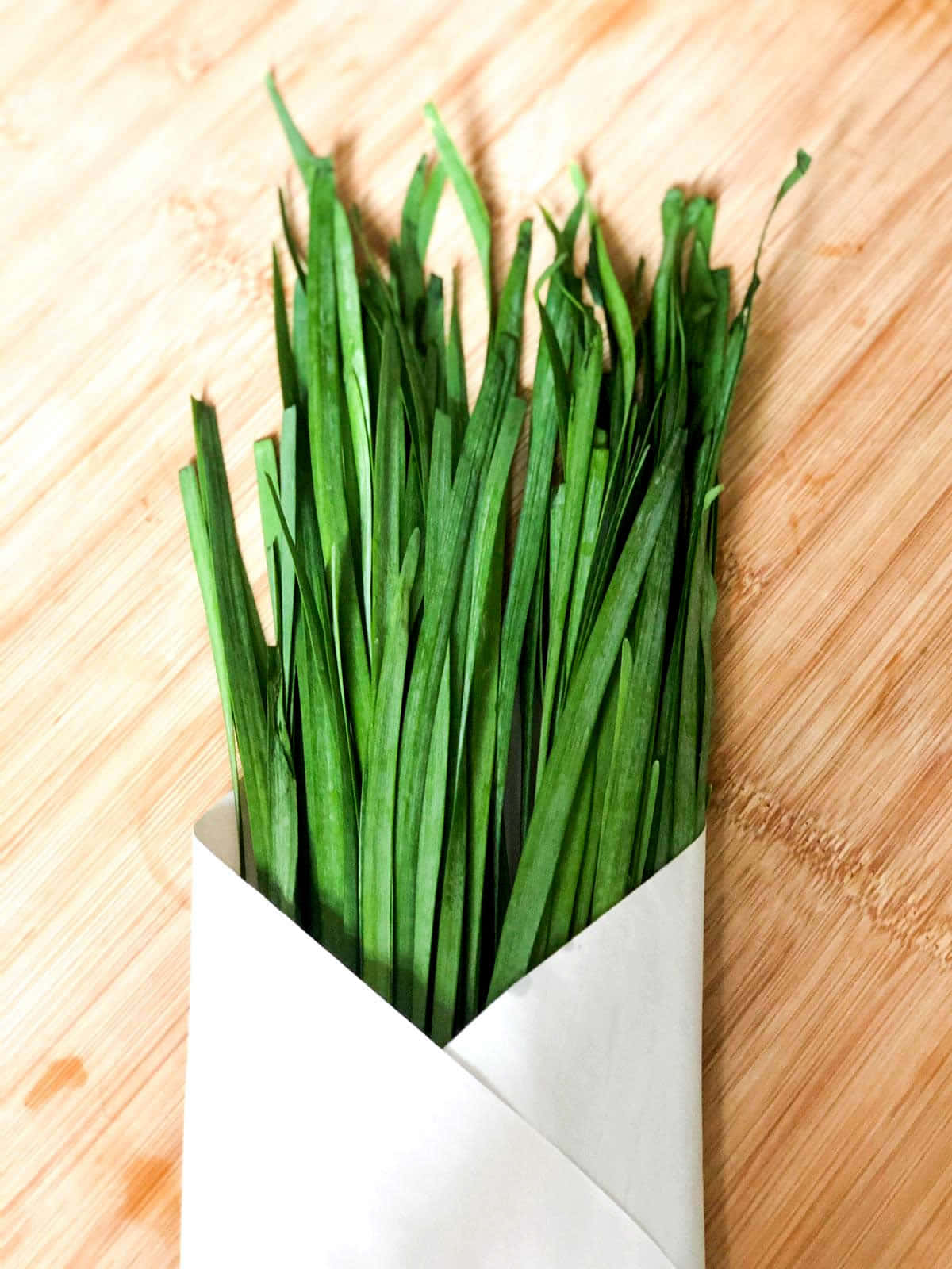 Freshly harvested green chives wrapped in white paper Wallpaper