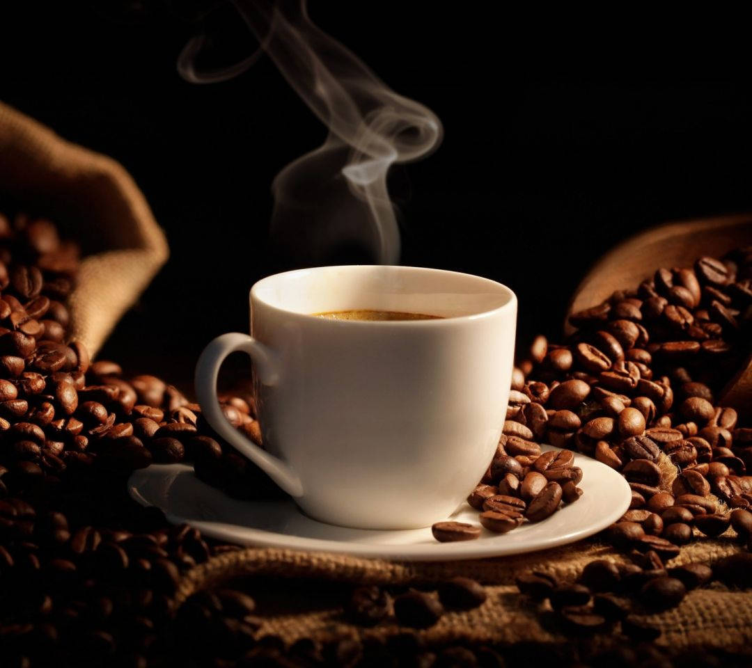 Fresh Mug Of Coffee With Coffee Beans Wallpaper