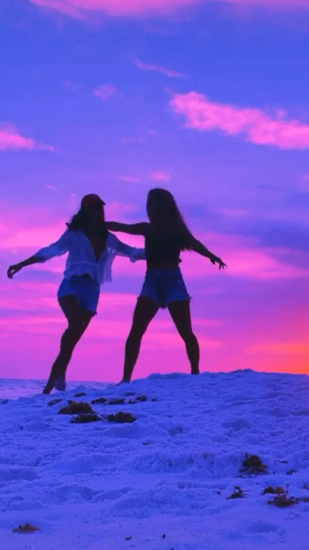 Two Girls Standing On The Beach At Sunset
