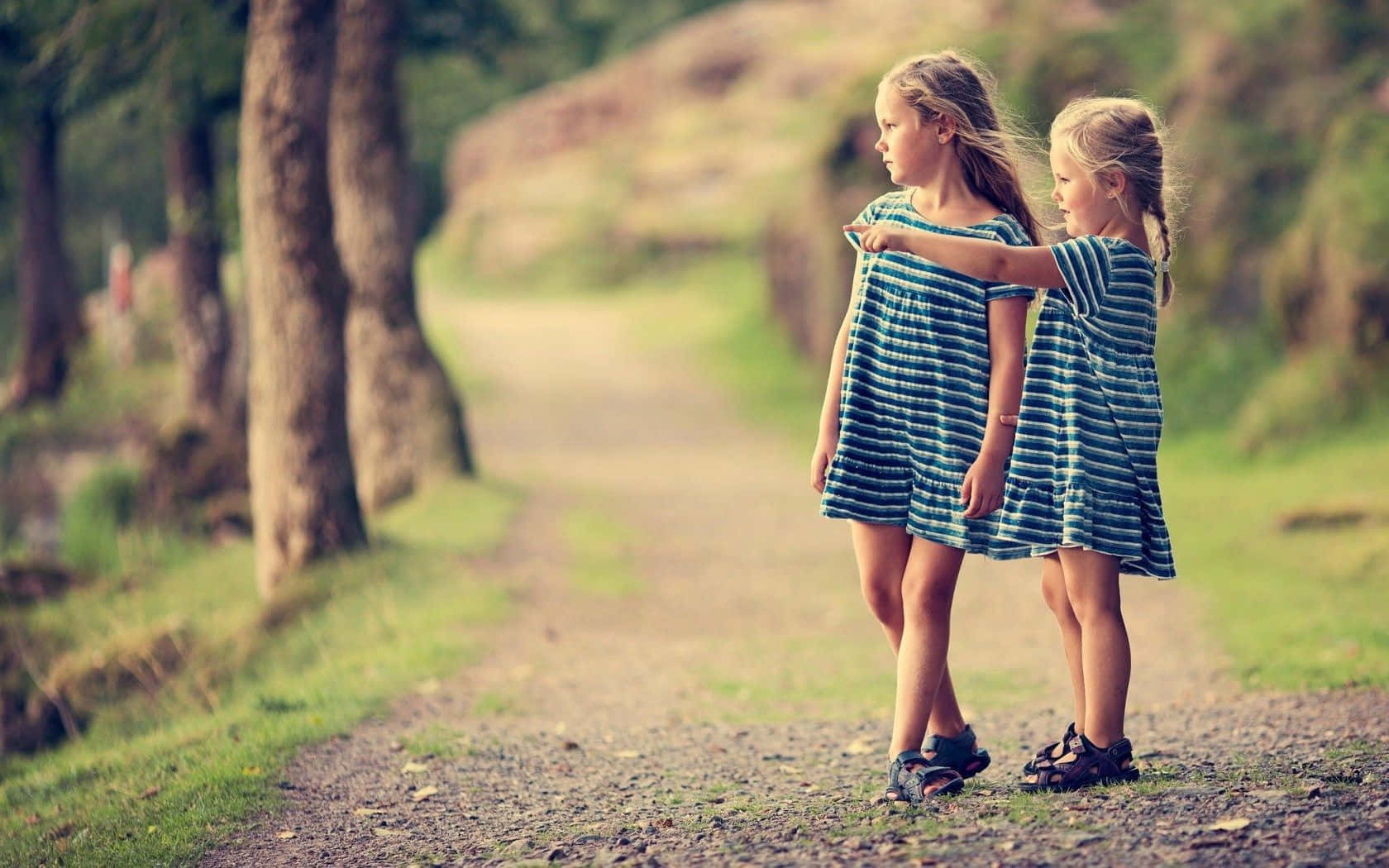 Freundschaftbild Von Kleinen Mädchen In Passenden Kleidern Im Wald