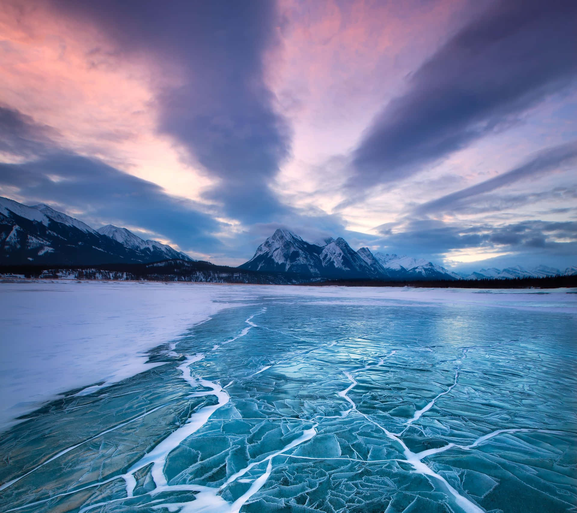 Frozen Lake Amidst Snowy Mountains Wallpaper