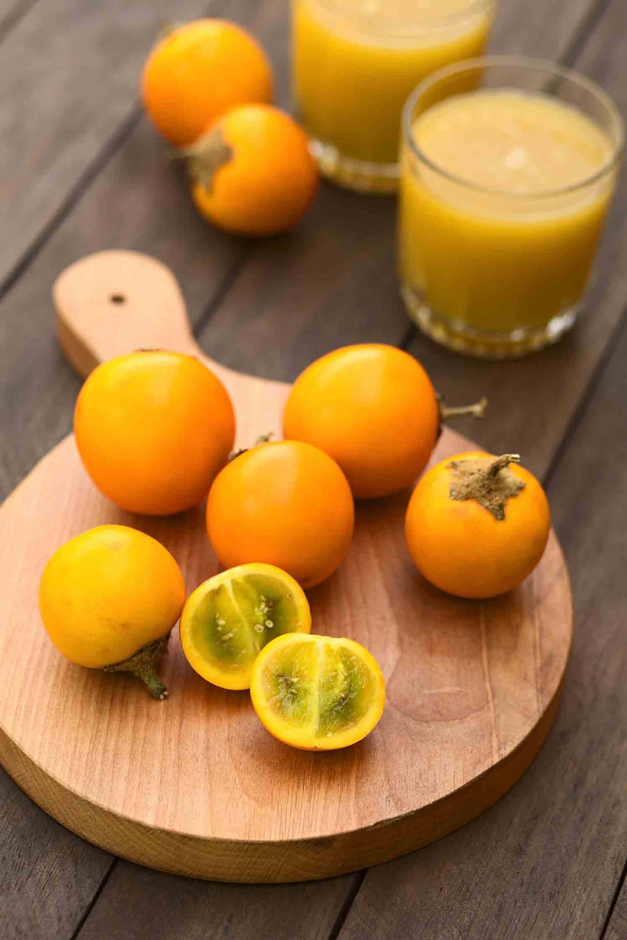 A Wooden Cutting Board With A Few Yellow Fruits On It