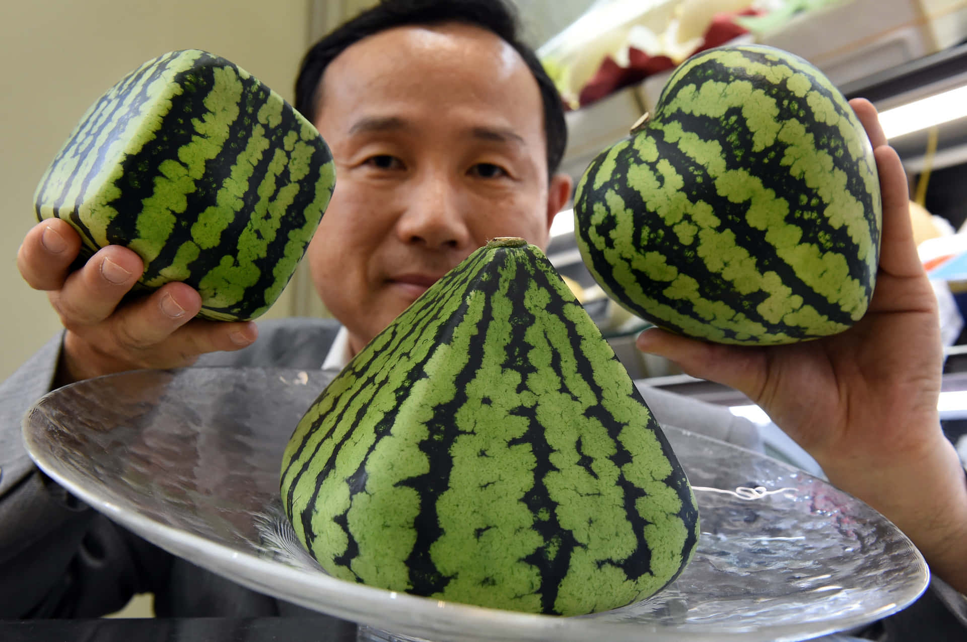 A Man Holding Up Three Watermelon Slices