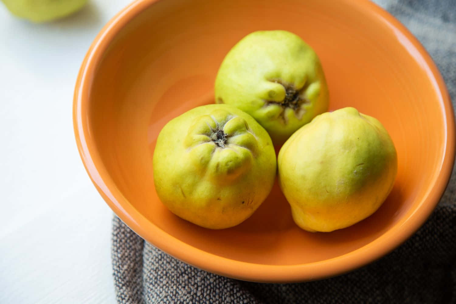 A Bowl Of Guavas On A Table