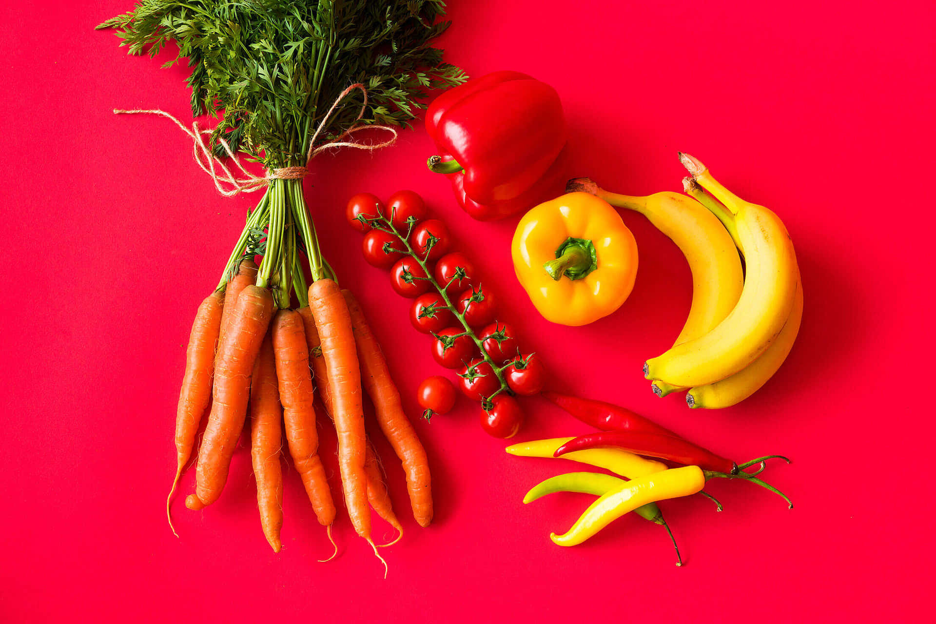 A Bunch Of Carrots, Bananas, And Other Vegetables On A Red Background