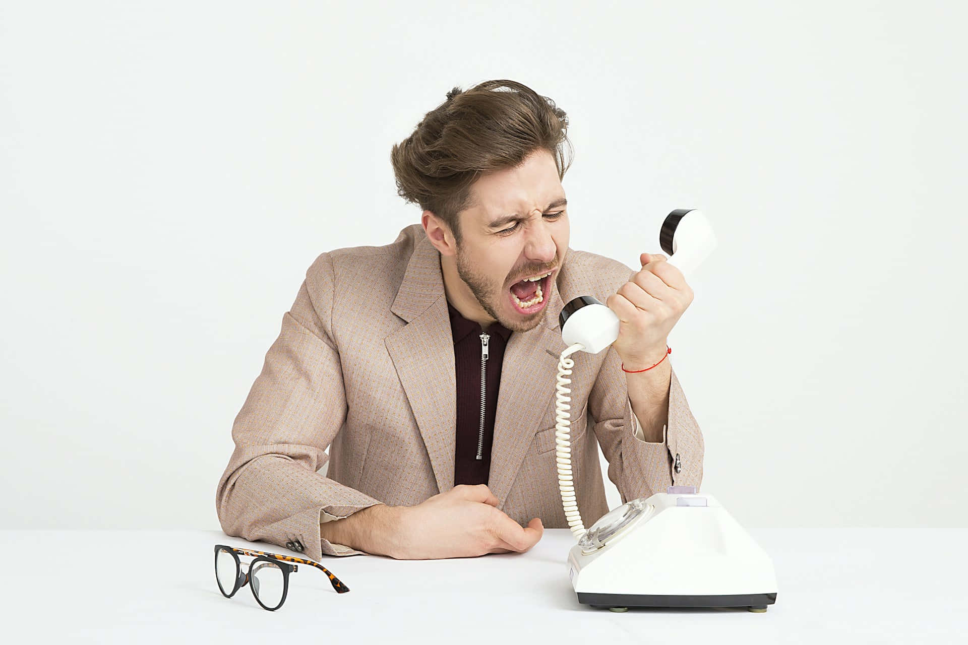 Frustrated Man Yelling Into Phone Wallpaper