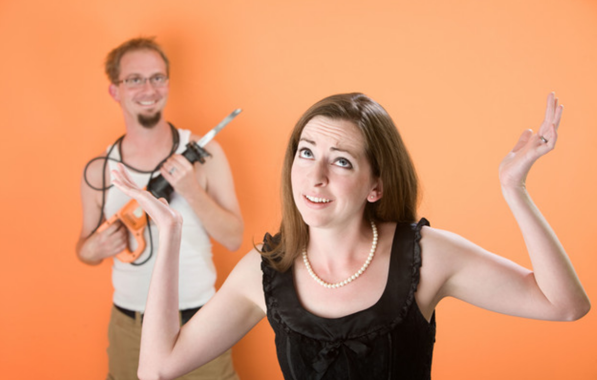 Frustrated Woman And A Man With Reciprocal Saw Against An Orange Background Wallpaper