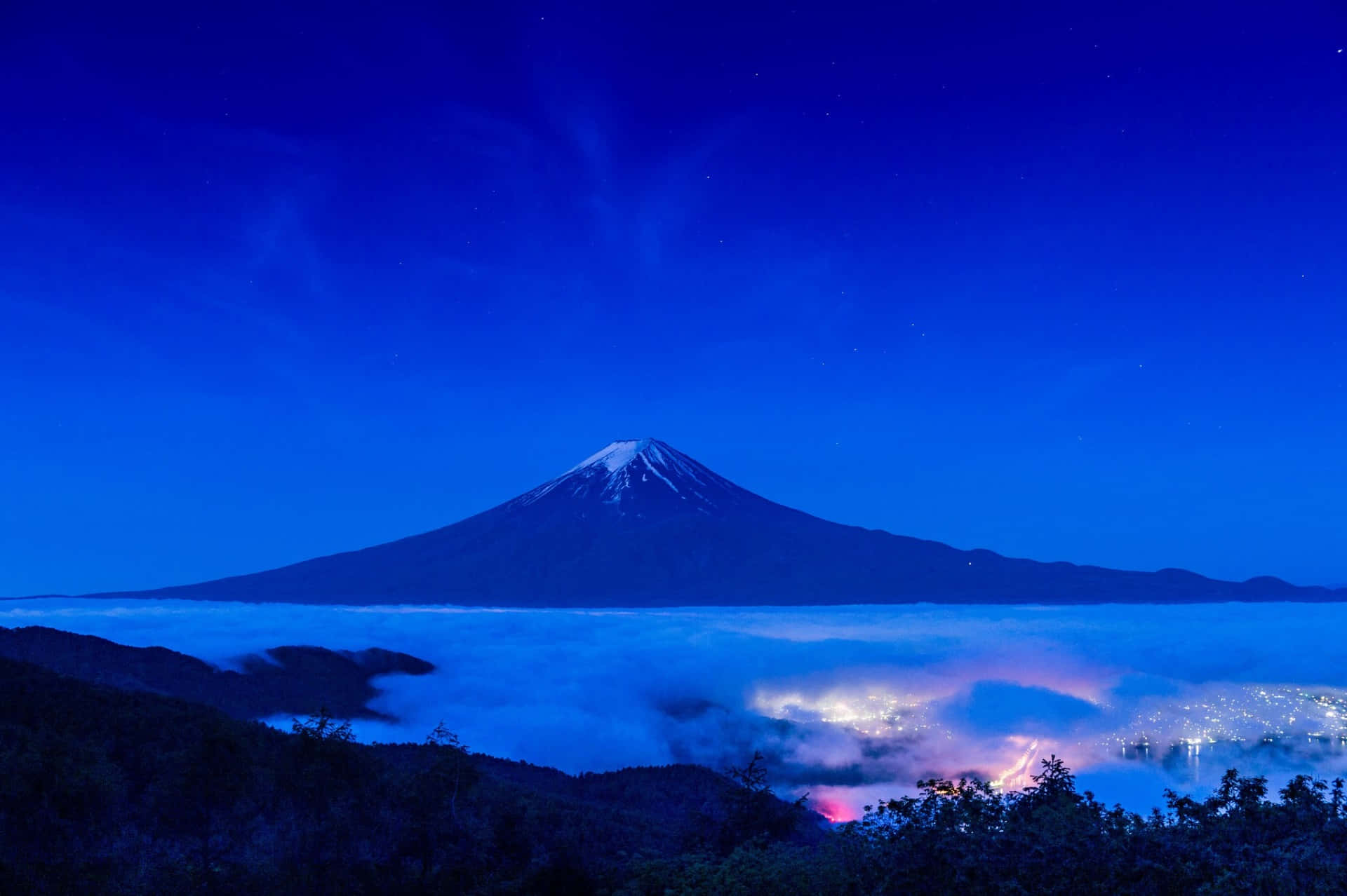 Fuji Peak Through The Clouds At Nighttime Wallpaper