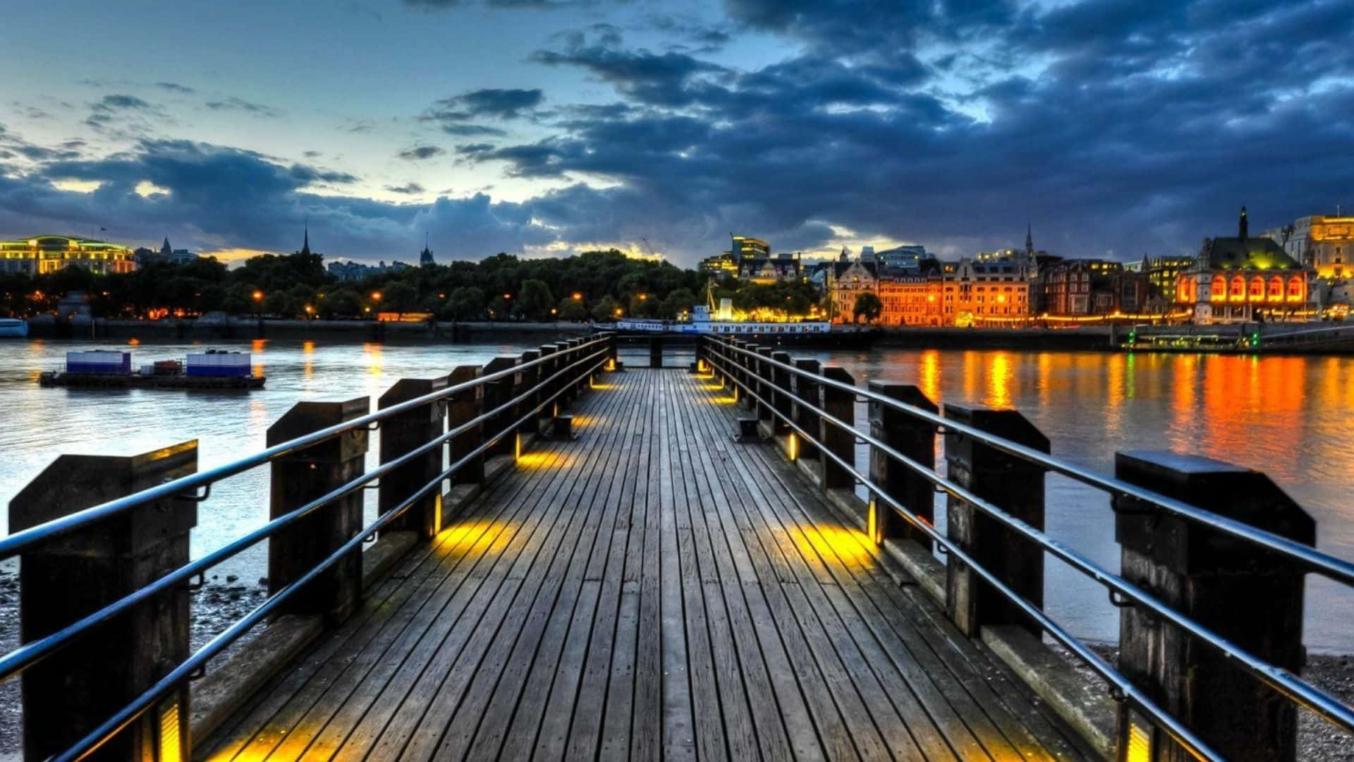 A Wooden Bridge Over A River At Night
