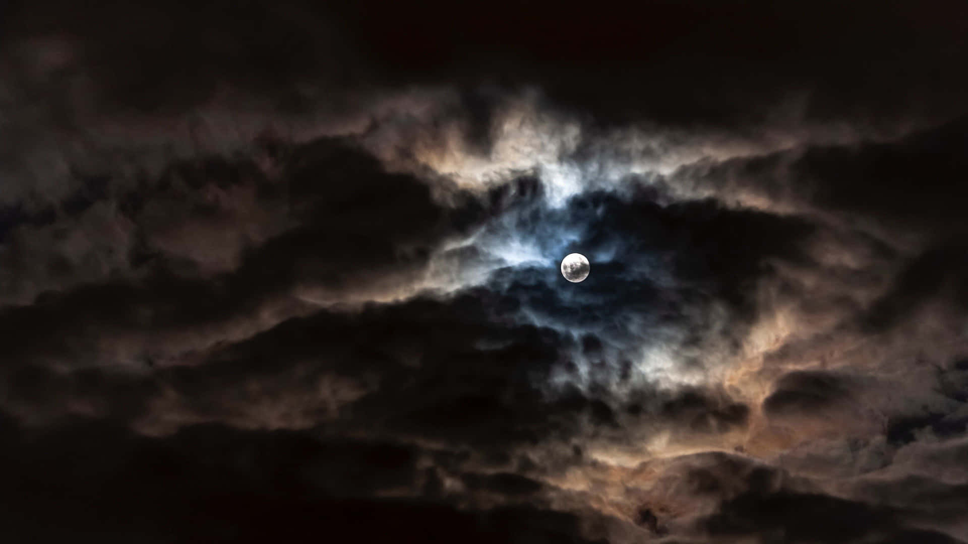 the moon is seen through the clouds