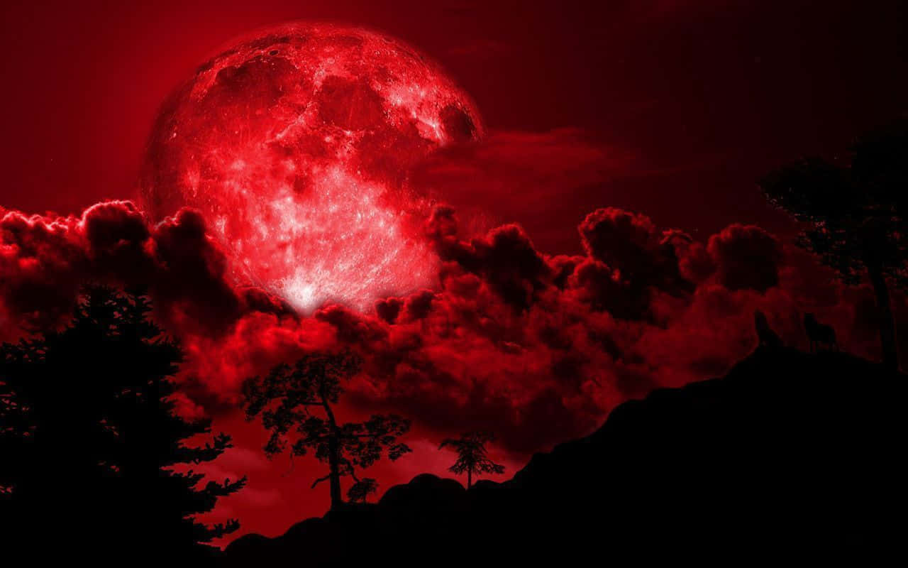 a red moon with clouds and trees in the background
