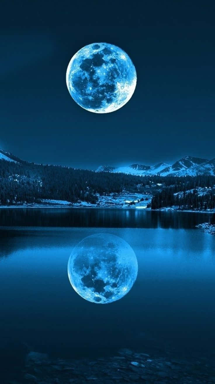 a blue moon is reflected in a lake