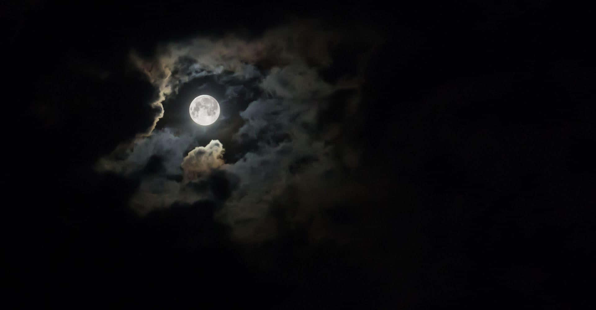 the moon is seen through the clouds