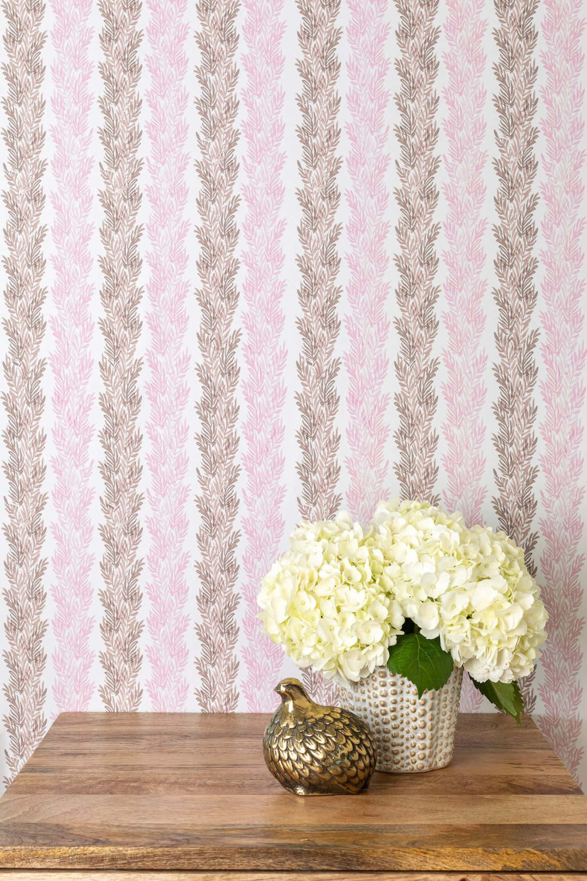 En pink og brun tapet med en vase med blomster Wallpaper