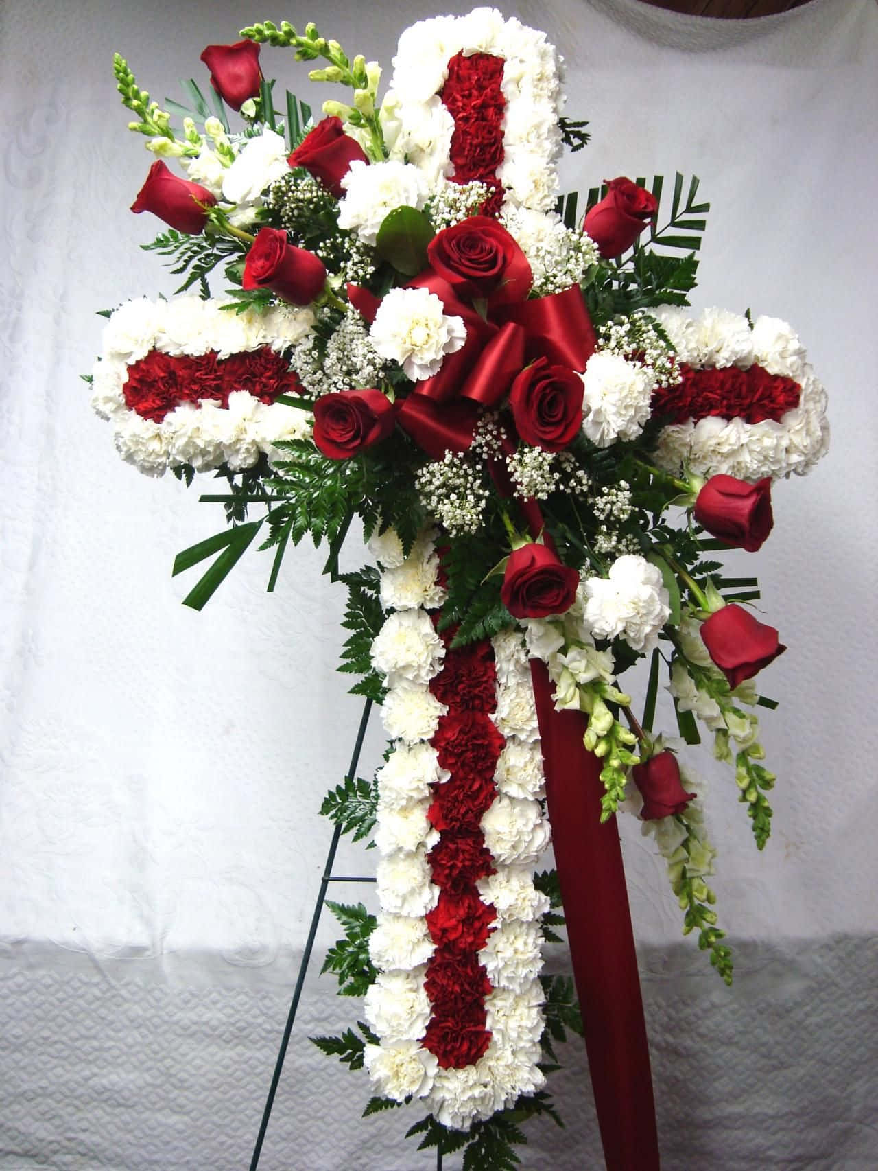 A Cross With Red And White Flowers
