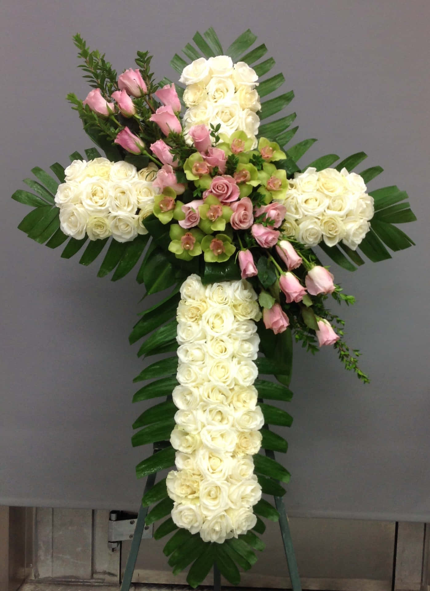 A Cross With Pink And White Flowers