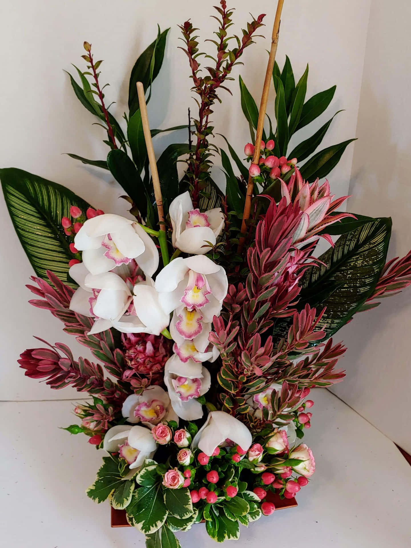 A White And Pink Arrangement With Orchids And Greenery