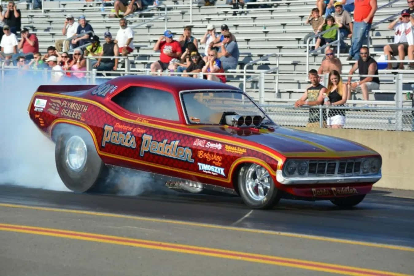A Drag Car Is Driving Down The Track