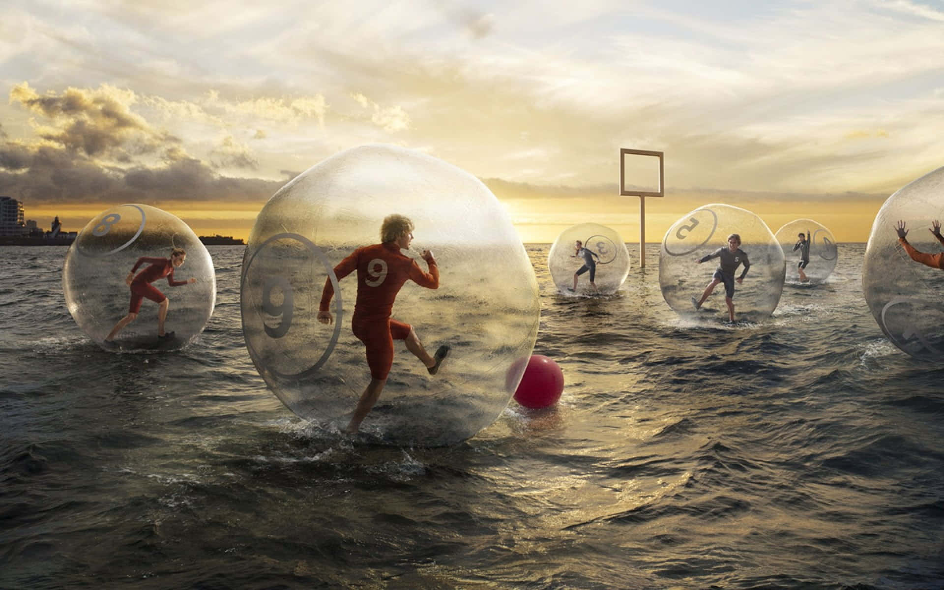 A Group Of People In Bubbles Playing Soccer In The Ocean