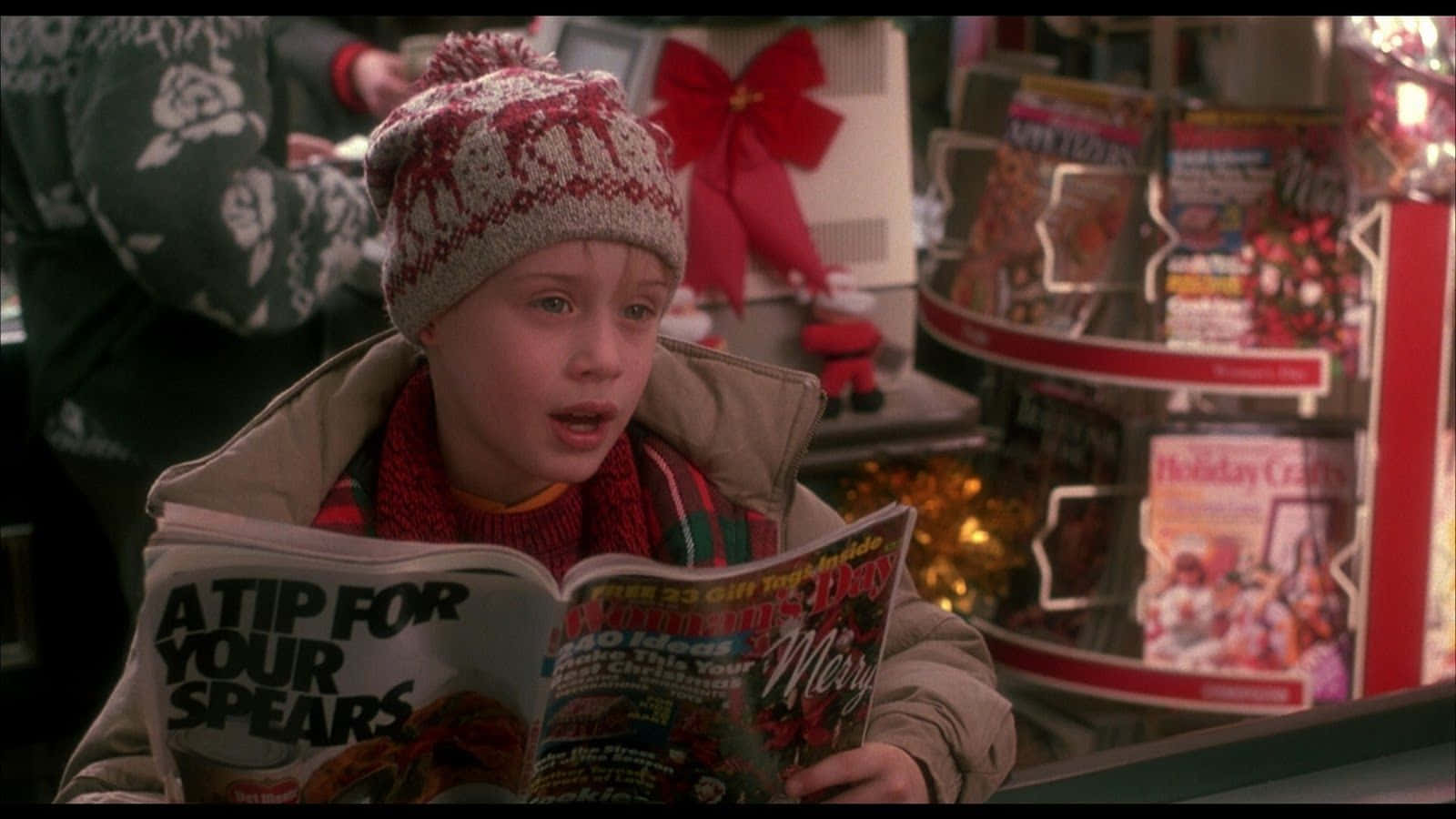 A Young Boy Reading A Christmas Magazine In A Store Wallpaper
