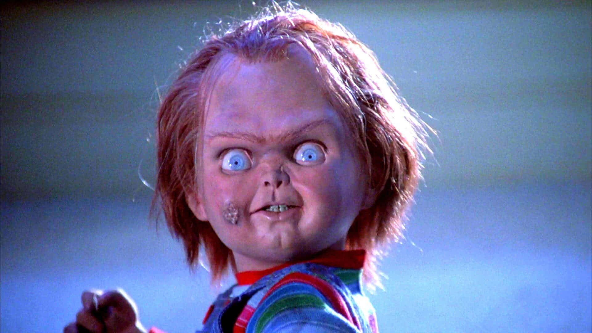 Imagemdo Chucky, O Boneco Assassino, Do Filme Brinquedo Assassino, Com Uma Expressão Engraçada E Assustadora, Como Papel De Parede De Computador Ou Celular.