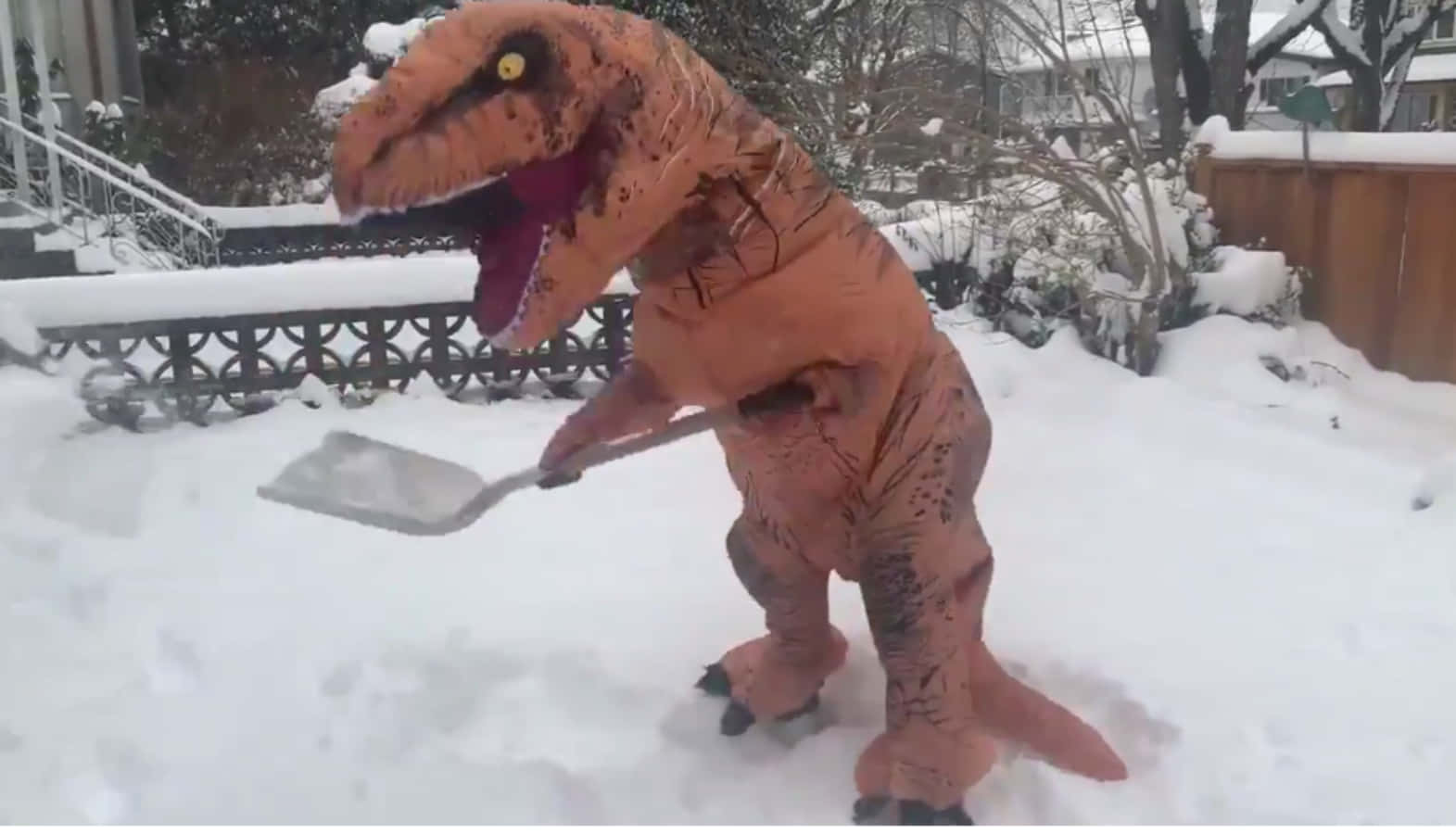 Divertenteimmagine Di Un T-rex Con Costume Che Spala La Neve