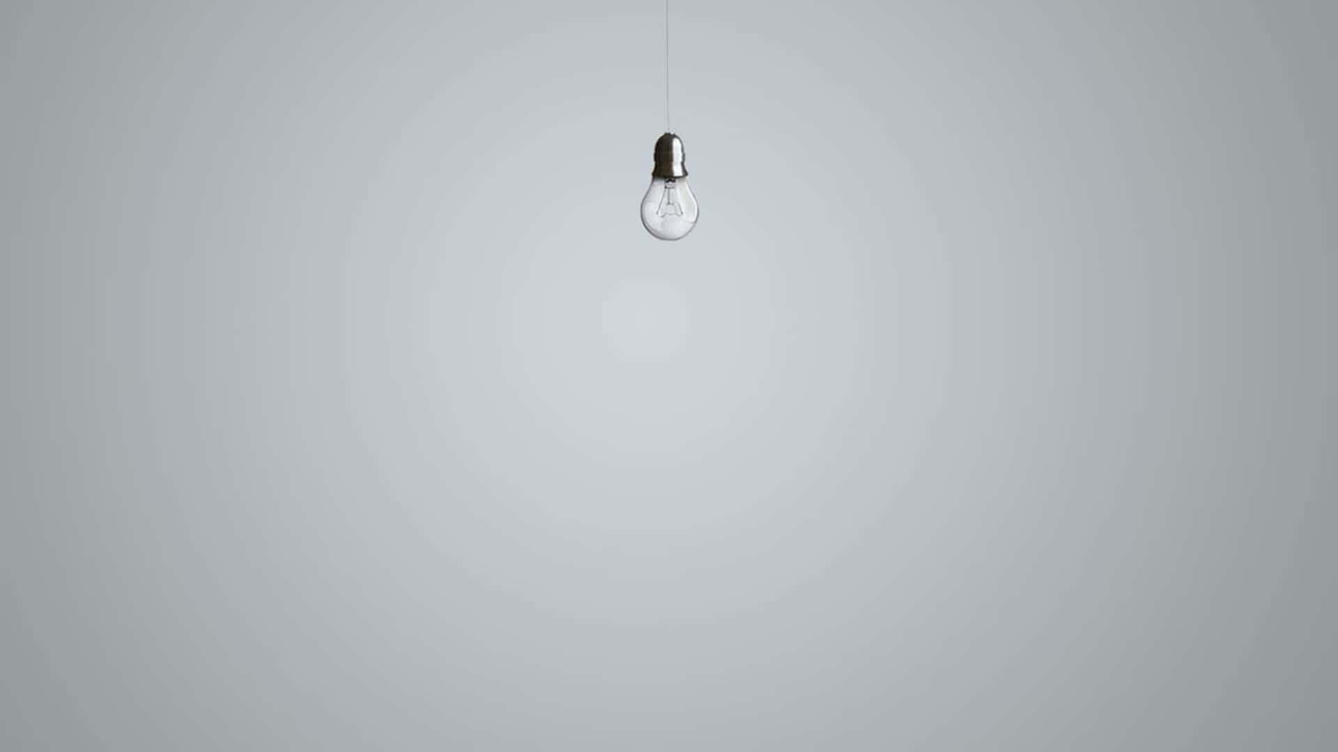A Light Bulb Hanging From A Gray Background