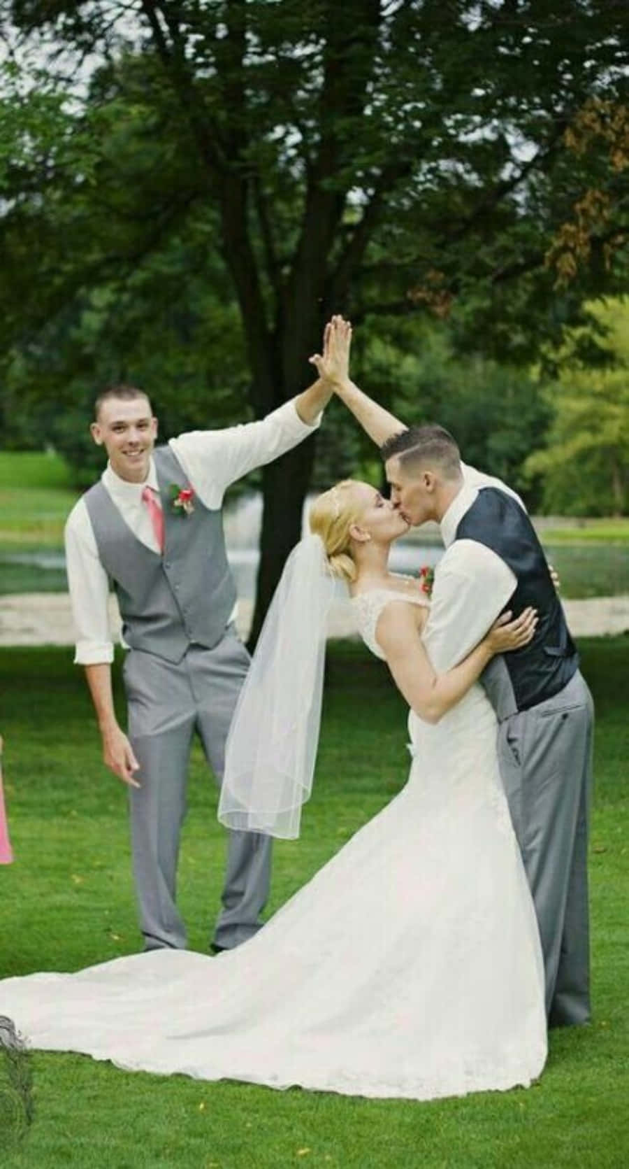 A Bride And Groom Are Holding Hands In The Grass