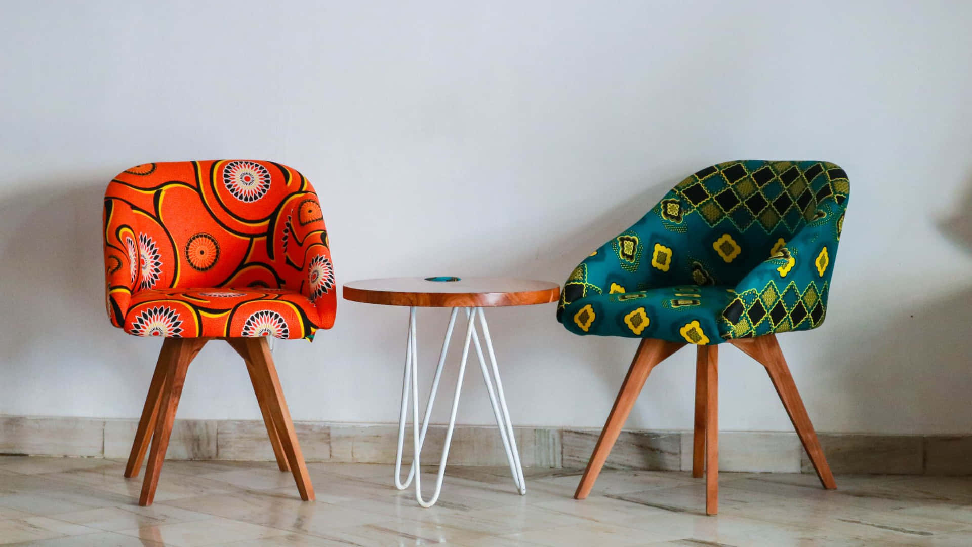 Two Chairs With Colorful Patterned Fabric And A Table