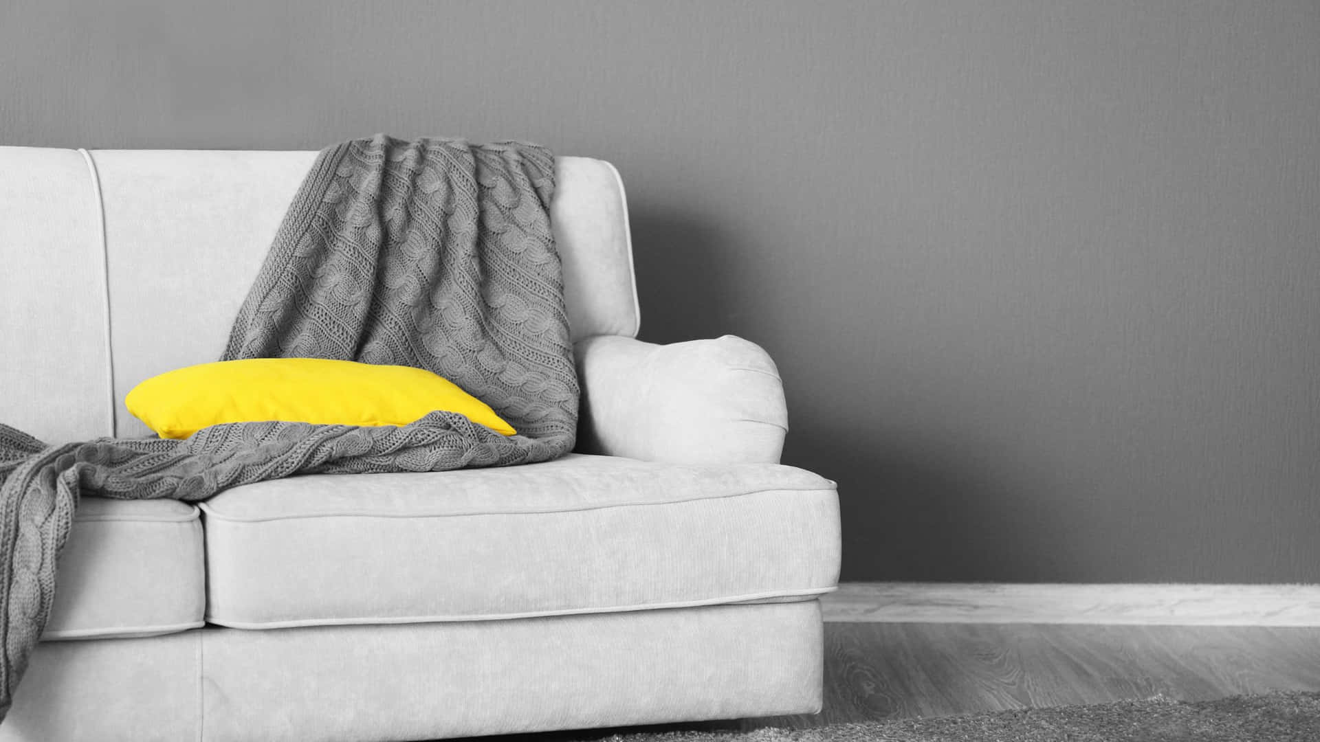 A White Couch With A Yellow Blanket