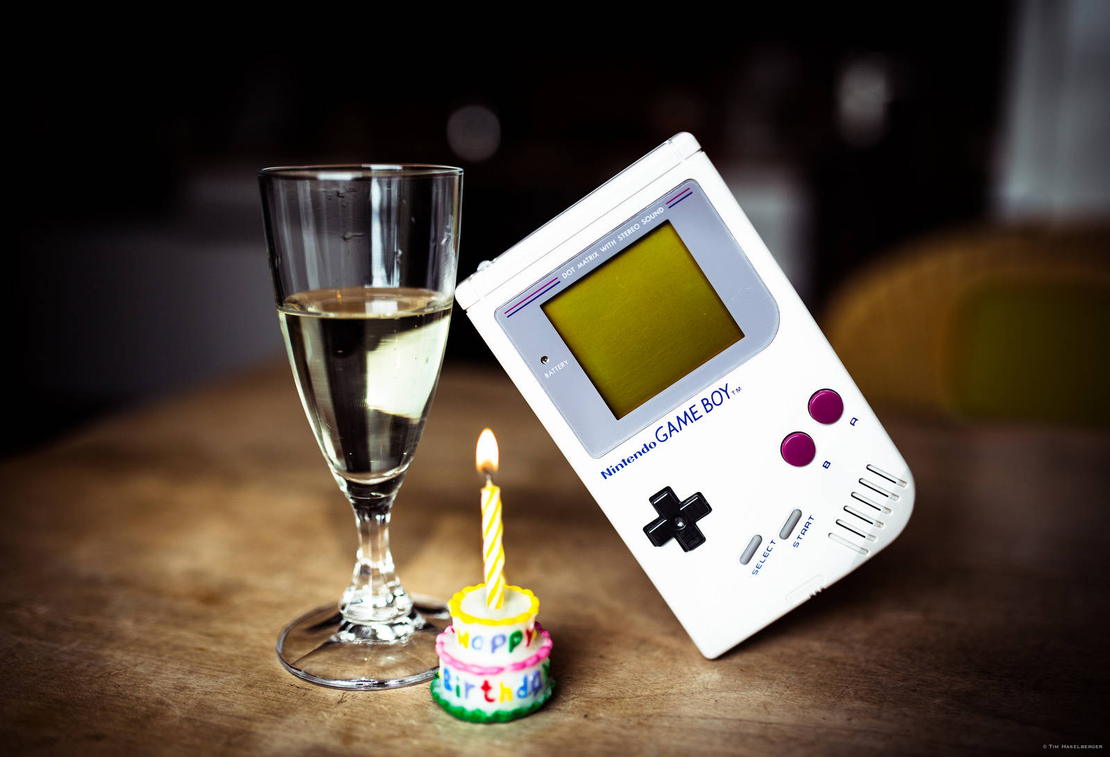 Vintage Game Boy Replica Displayed on Glass Table with a Slice of Cake Wallpaper